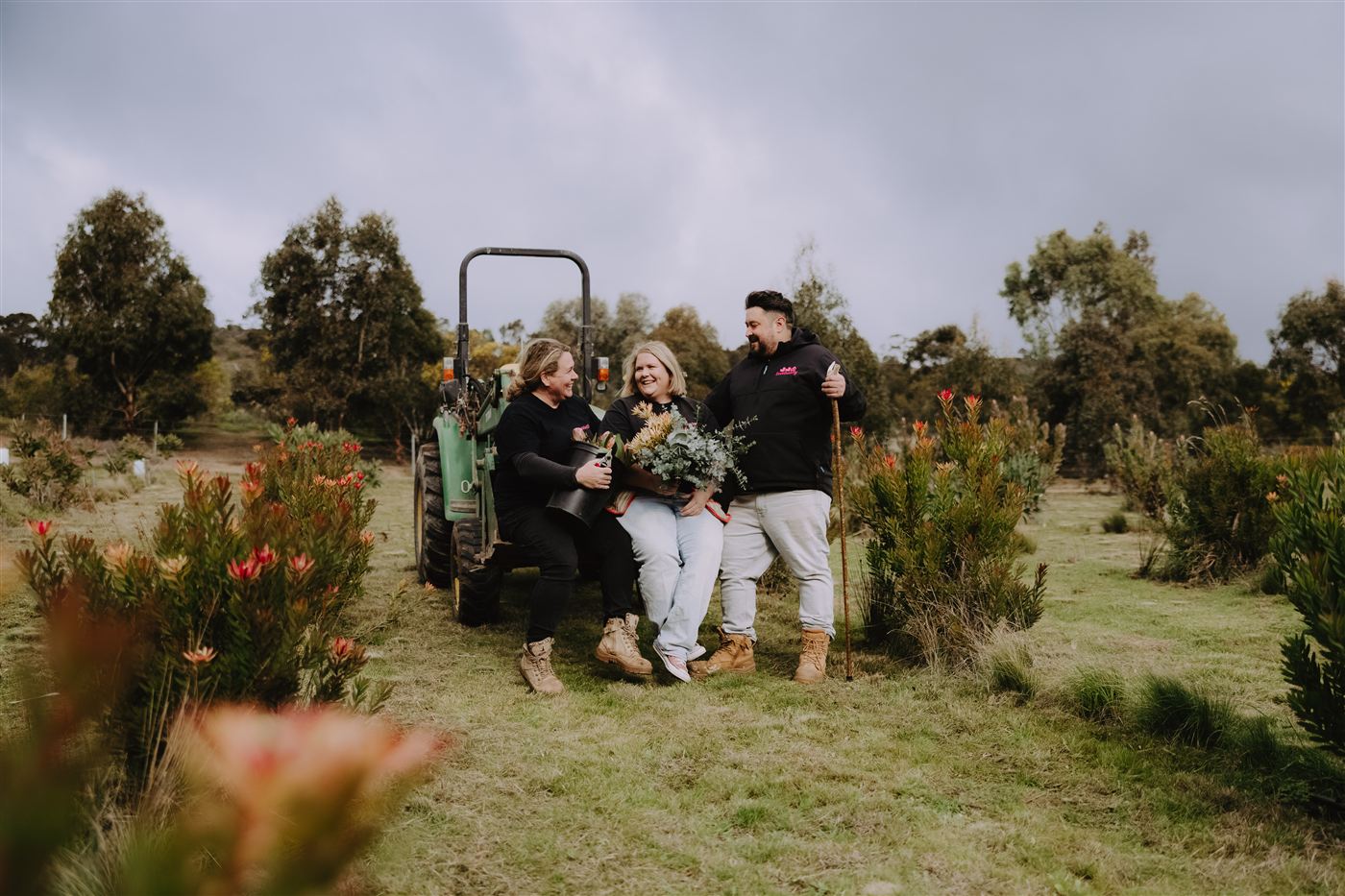 The three of us sitting on the back of the tractor among the proteas, holding bunches of flowers