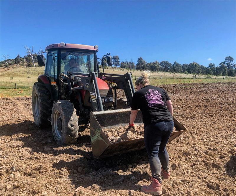 Checking the tractor bucket in a freshly worked paddock